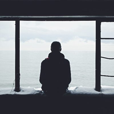 창밖을 바라보며 생각에 잠긴 사람의 실루엣