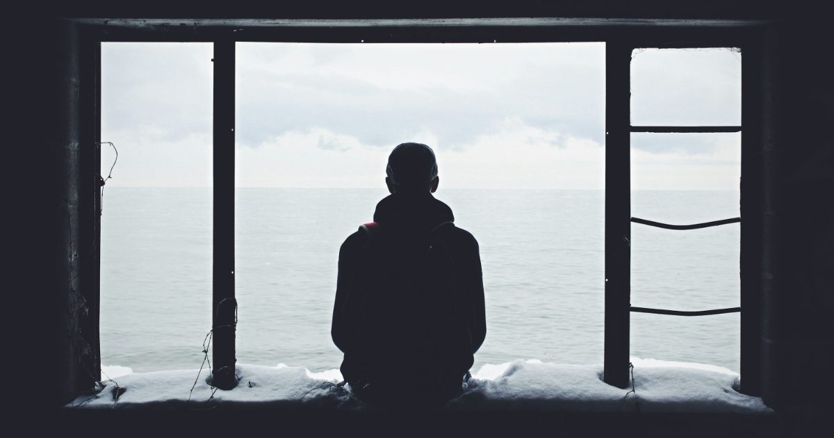 창밖을 바라보며 생각에 잠긴 사람의 실루엣