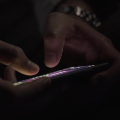 휴대폰을 손에 쥔 채 화면을 켜지 않고 있는 사람