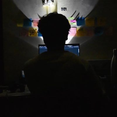 어두운 방에서 노트북 화면을 보고 있는 사람